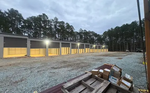 New LED lighting along a row of commercial storage units at dusk