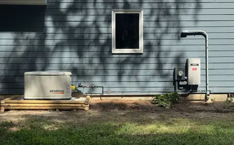 A Generac standby generator installed beside a house