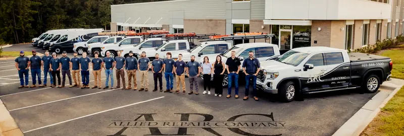 The full ARC crew standing in a line in front of the shop and service trucks