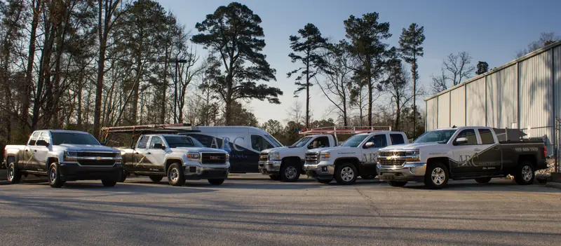 A row of ARC service trucks parked outside the shop